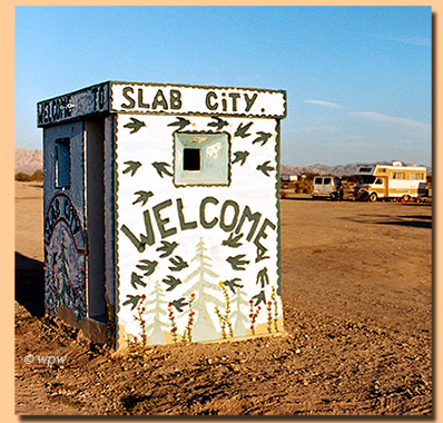 <Welcome to Slab City, painted on the outside of an old sentry post>