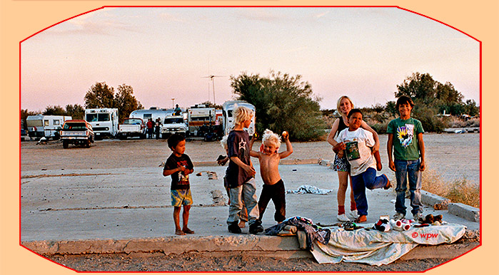 <Photo by Wolf P. Weber of 6 kids having fun on a concrete slab at Slab City, Niland CA, end of day warm light>